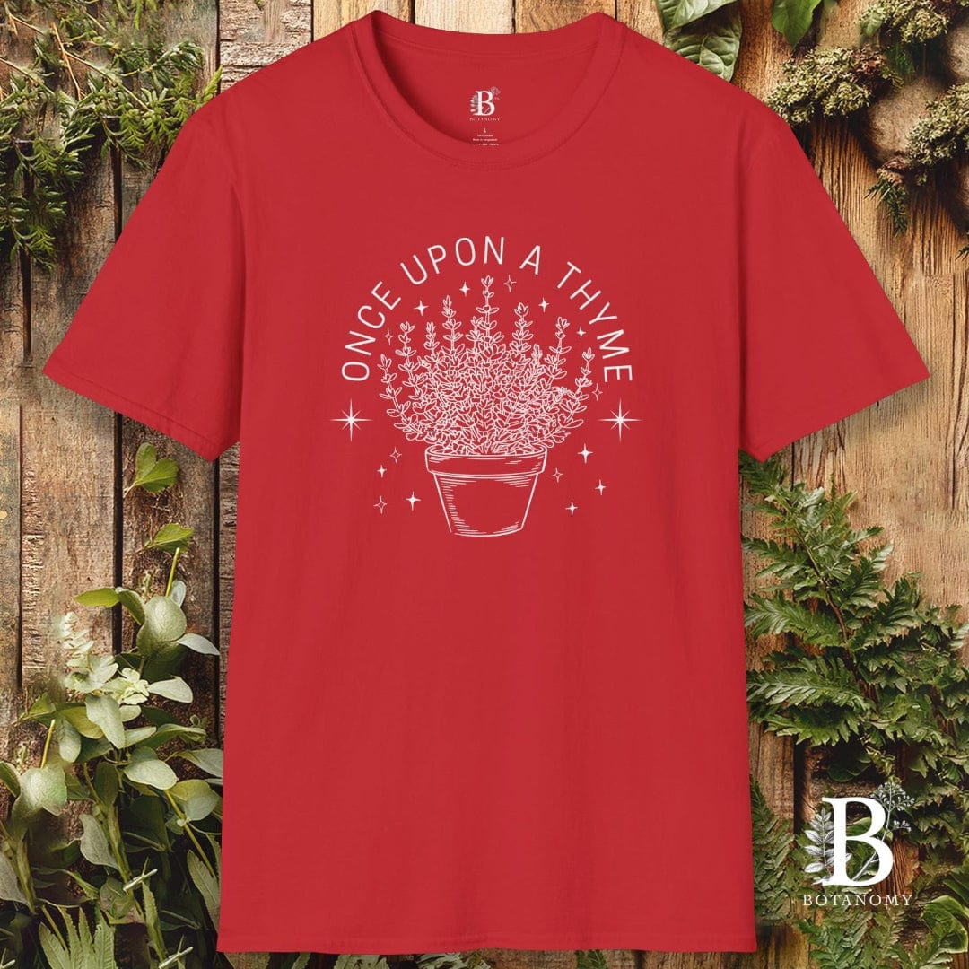 Red t-shirt with white graphic and text 'Once Upon a Thyme' on a wooden background with plants.