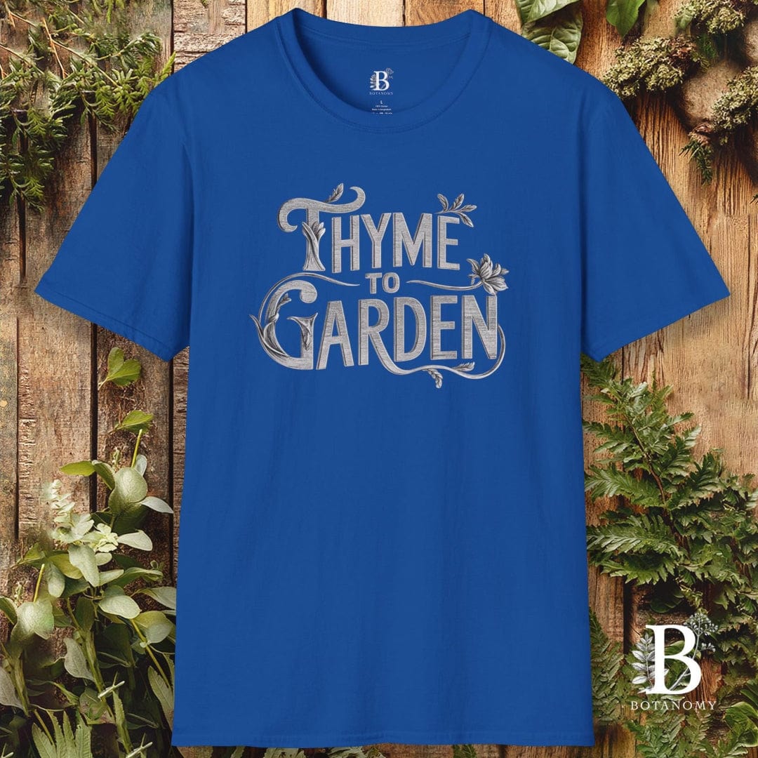 Blue t-shirt with 'Thyme to Garden' text on a wooden background with plants