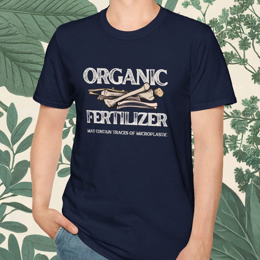 Person wearing a navy blue t-shirt with 'Organic Fertilizer' text, standing against a leafy background.