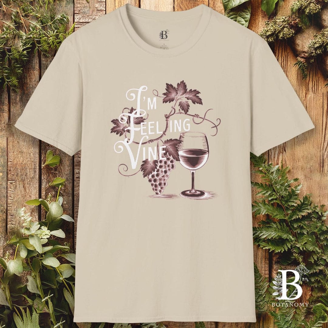Beige t-shirt with a graphic design and text on a wooden background with plants