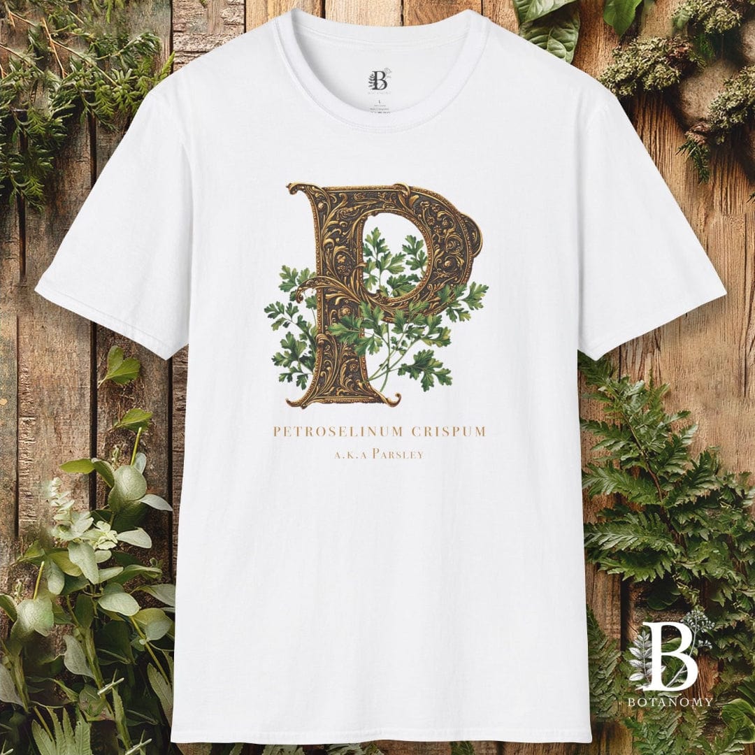 White t-shirt with decorative letter 'P' design on a wooden background with greenery