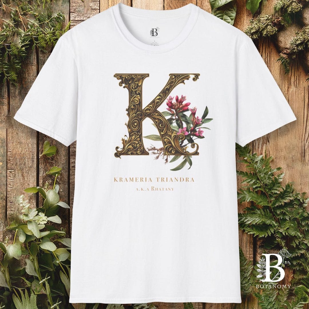 White t-shirt with floral 'K' design on a wooden background