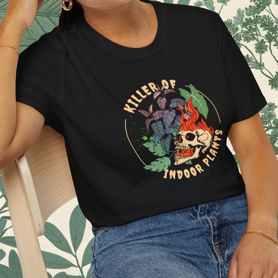 Woman wearing a black t-shirt with a colorful graphic design sitting on a chair.