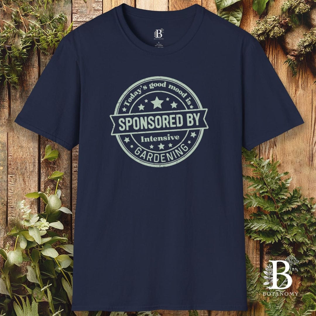 Navy blue t-shirt with a printed design on a wooden background with plants.