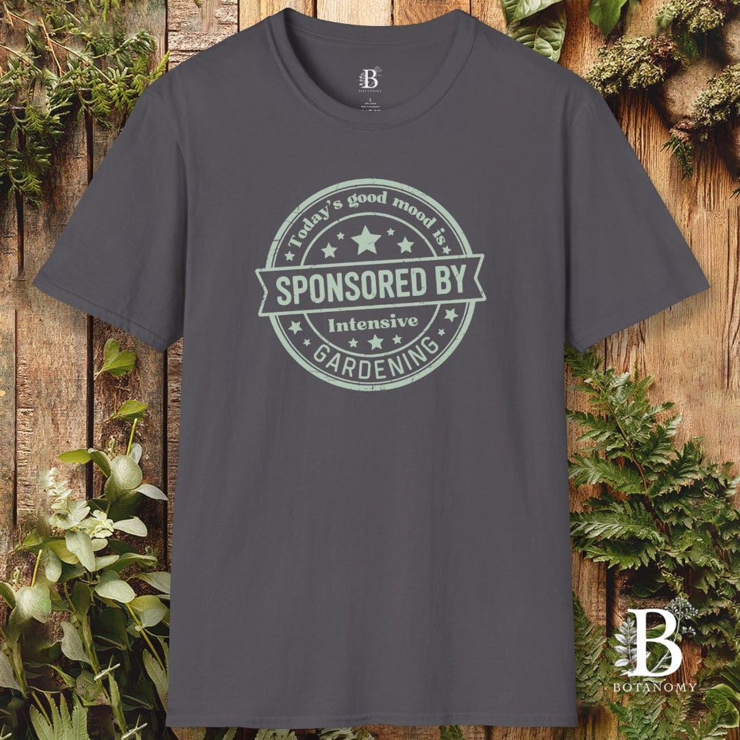 Gray t-shirt with a printed design on a wooden background with plants