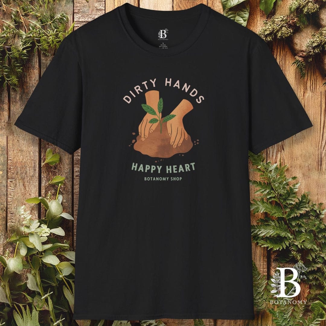 Black t-shirt with 'Dirty Hands, Happy Heart' graphic and brand logo on a wooden background with plants.