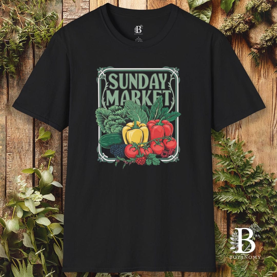 Black t-shirt with 'Sunday Market' graphic design featuring fruits and vegetables on a wooden background.