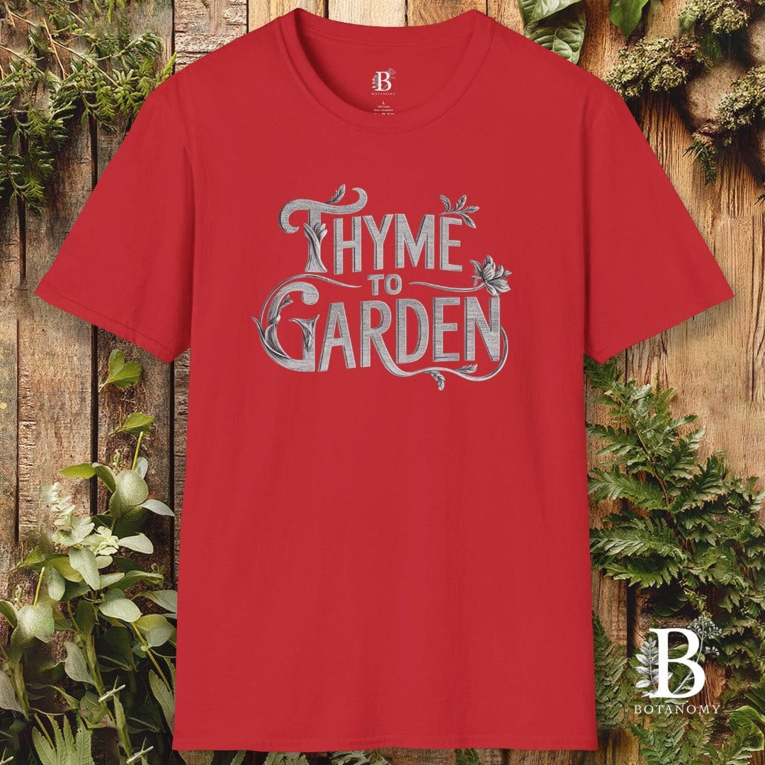 Red t-shirt with 'Thyme to Garden' text on a wooden background with plants