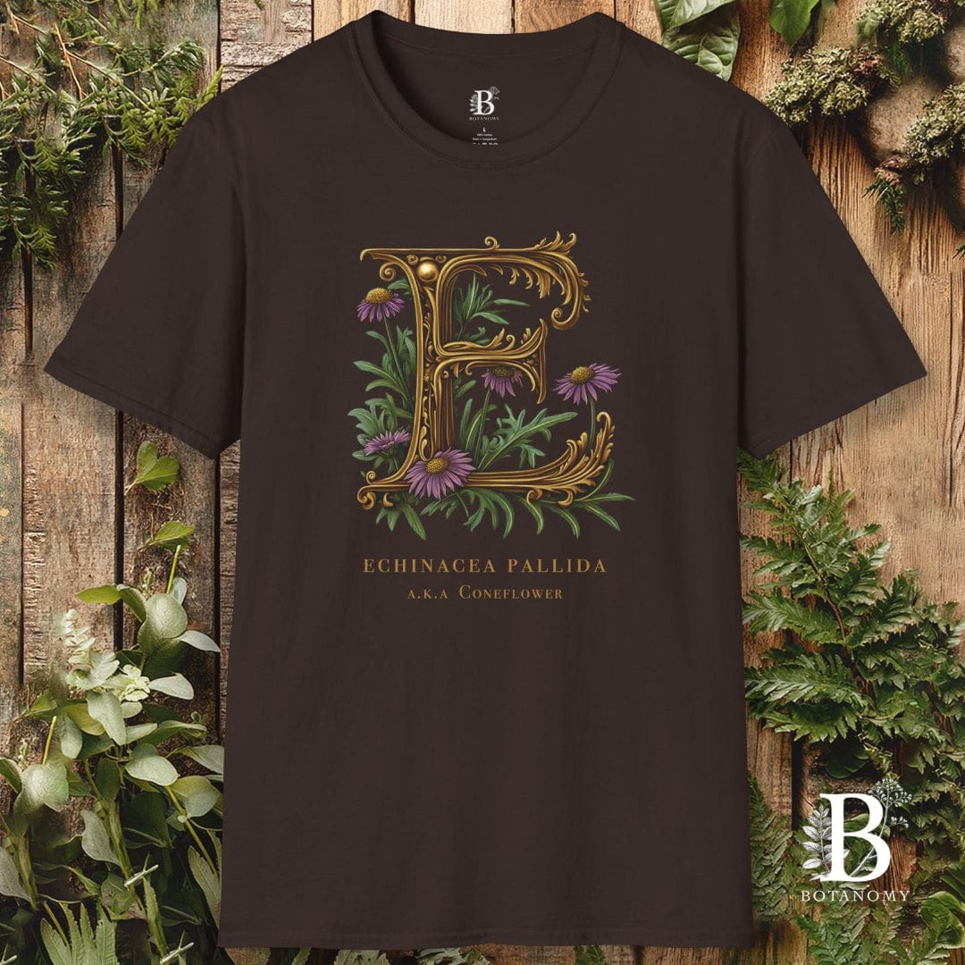Brown t-shirt with decorative letter 'E' and floral design on a wooden background