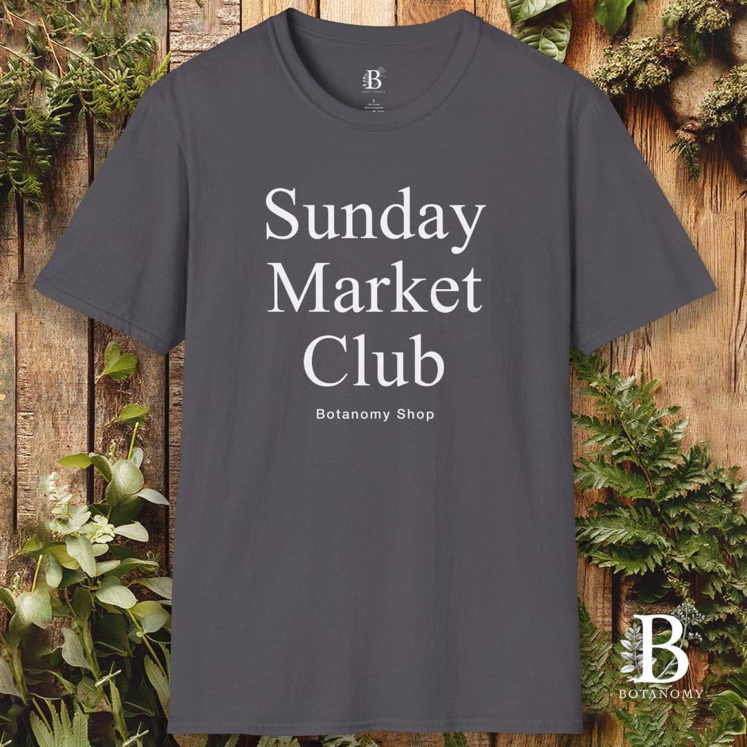 Gray t-shirt with 'Sunday Market Club' text on a wooden background with plants