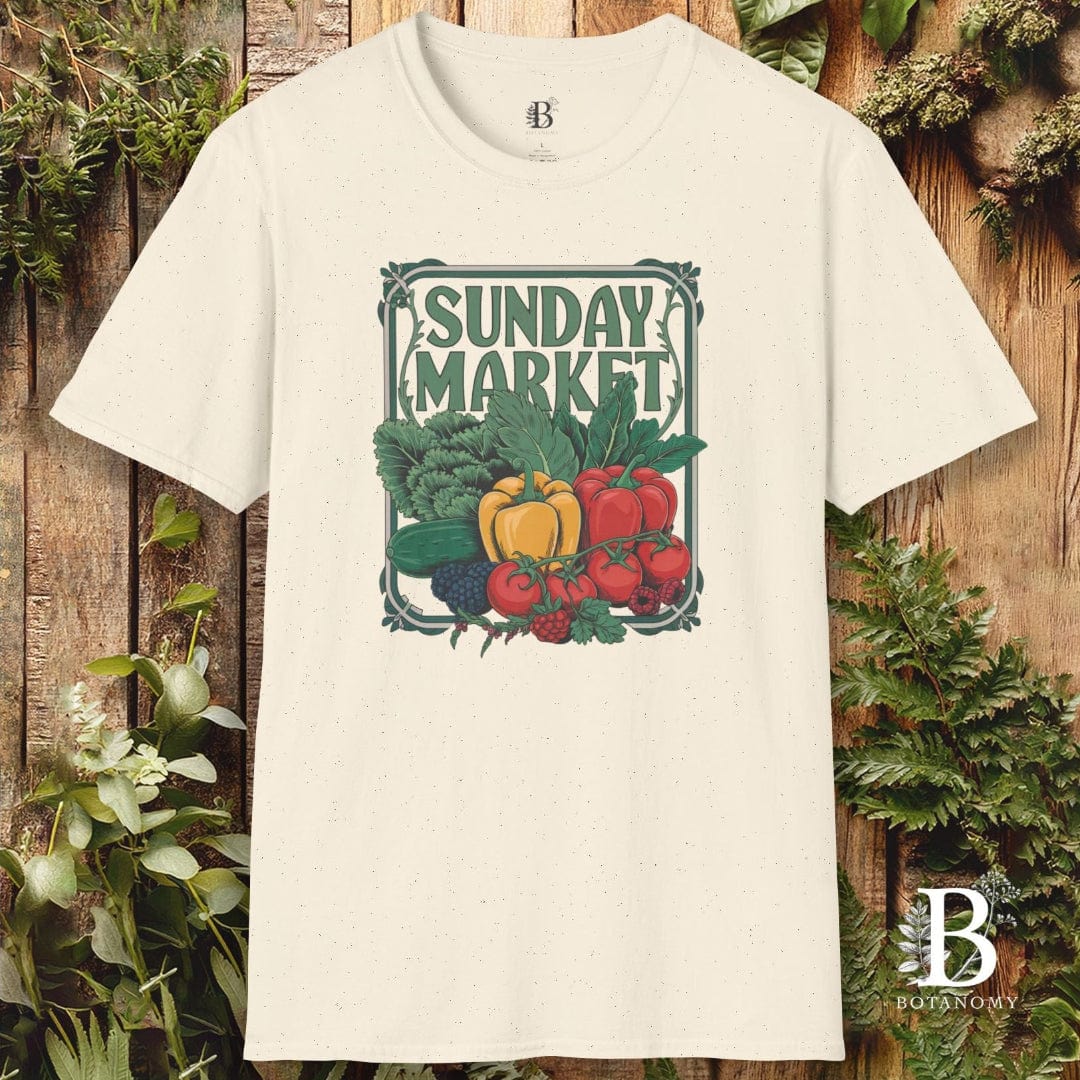 White t-shirt with 'Sunday Market' graphic design featuring vegetables on a wooden background.