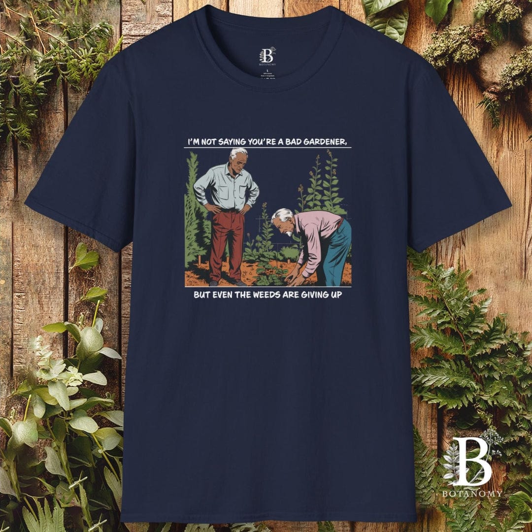 Navy blue t-shirt with graphic of two gardeners and text, displayed against a wooden background with plants.