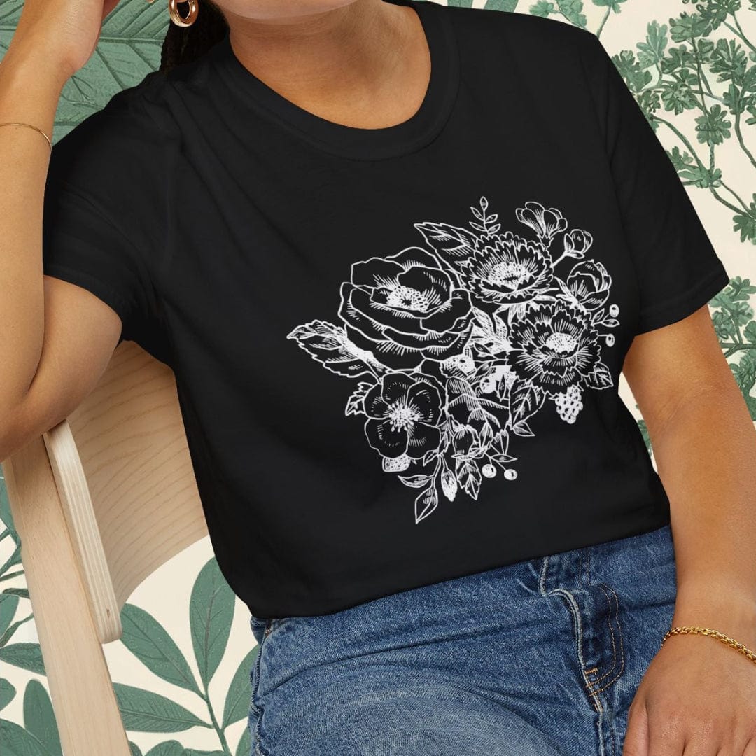 Woman wearing a black t-shirt with floral design sitting on a chair.