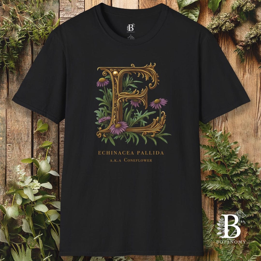 Black t-shirt with decorative letter 'E' design featuring flowers on a wooden background