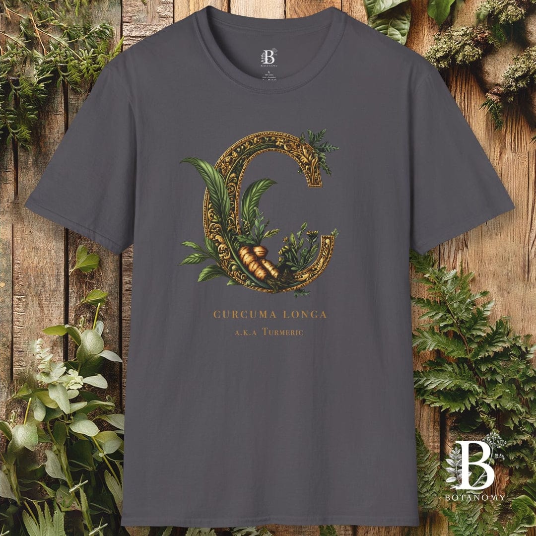 Gray t-shirt with decorative letter 'C' design on a wooden background with plants