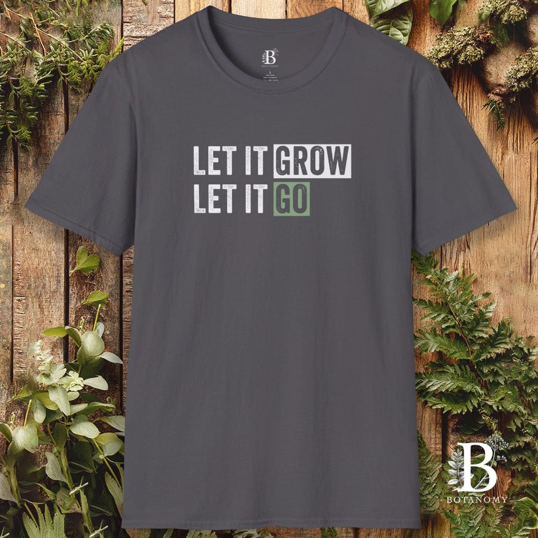 Gray t-shirt with 'LET IT GROW LET IT GO' text on a wooden background with plants.