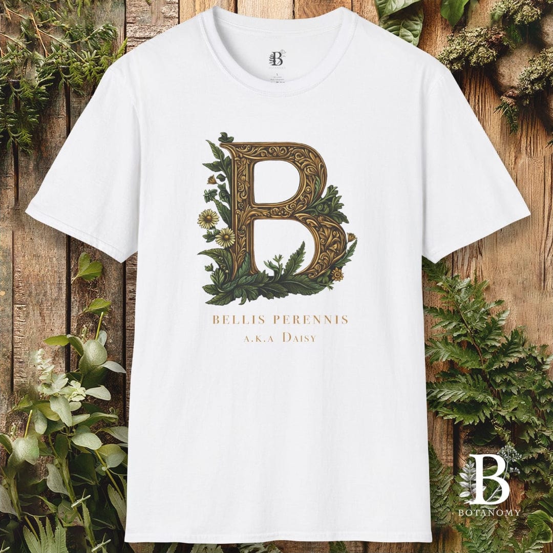 White t-shirt with decorative letter 'B' design on a wooden background with greenery