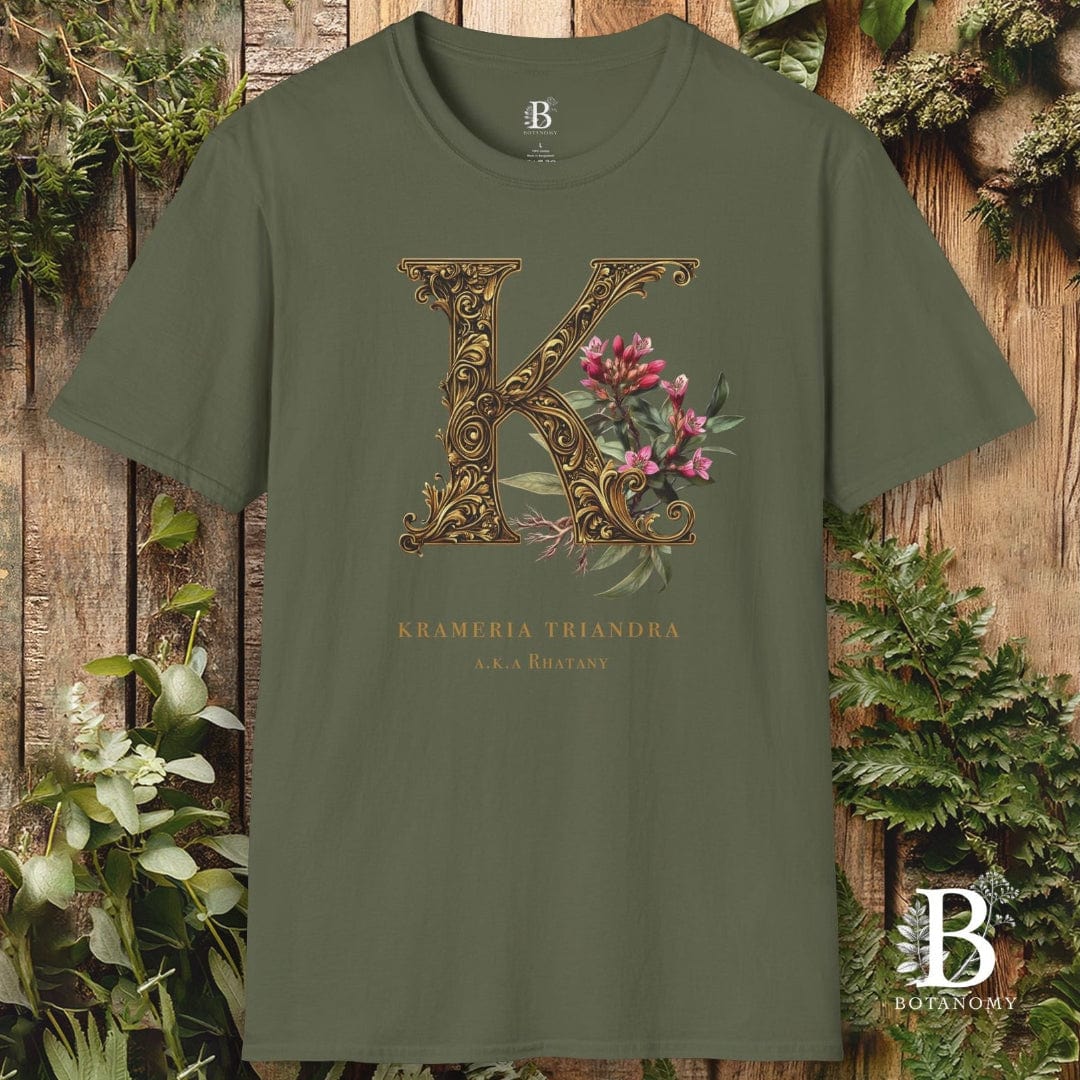 Green t-shirt with decorative letter 'K' design on a wooden background