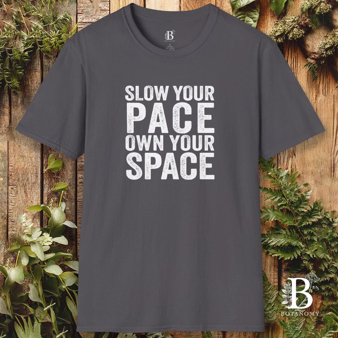Gray t-shirt with 'Slow your pace, own your space' text on a wooden background