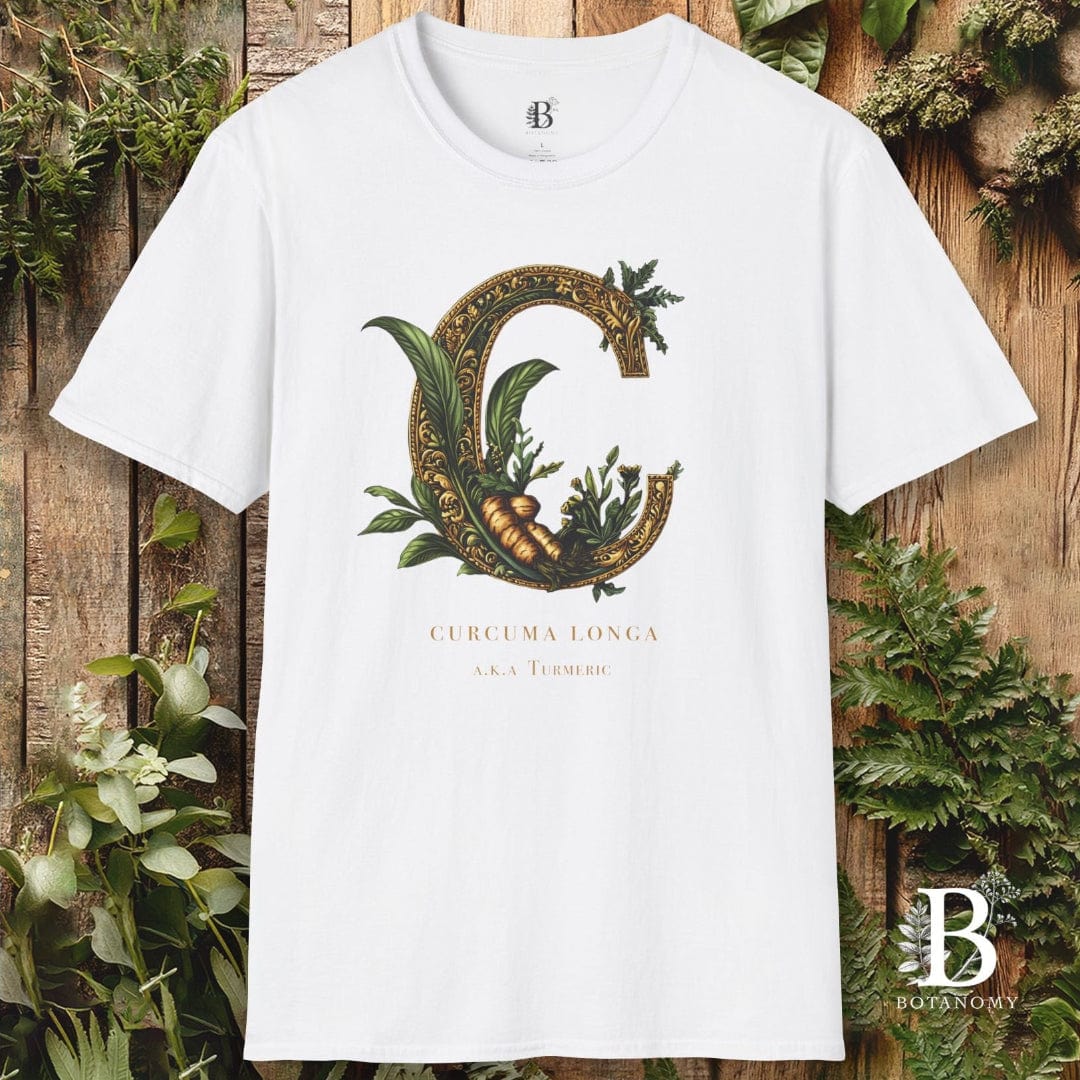 White t-shirt with decorative letter 'G' design on a wooden background with plants