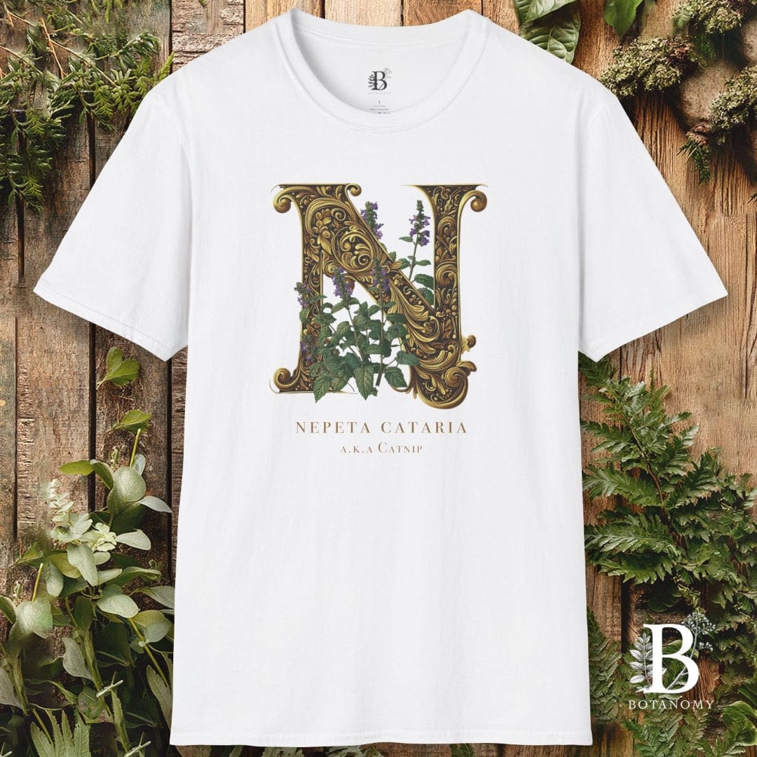 White t-shirt with decorative letter 'N' and plant design on a wooden background