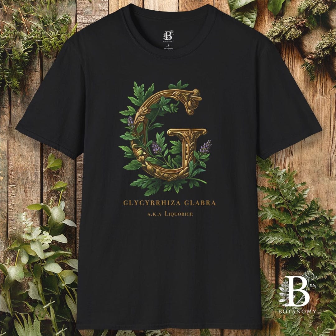 Black t-shirt with gold letter 'G' and green leaves on a wooden background