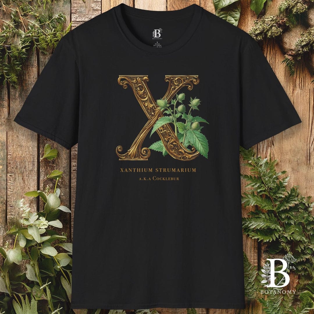 Black t-shirt with decorative letter 'X' design on a wooden background with plants