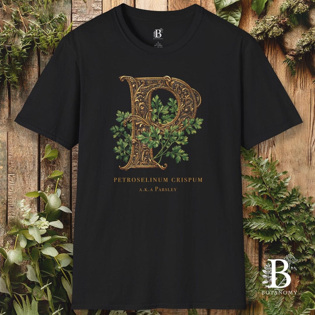 Black t-shirt with decorative letter 'P' design on a wooden background with plants