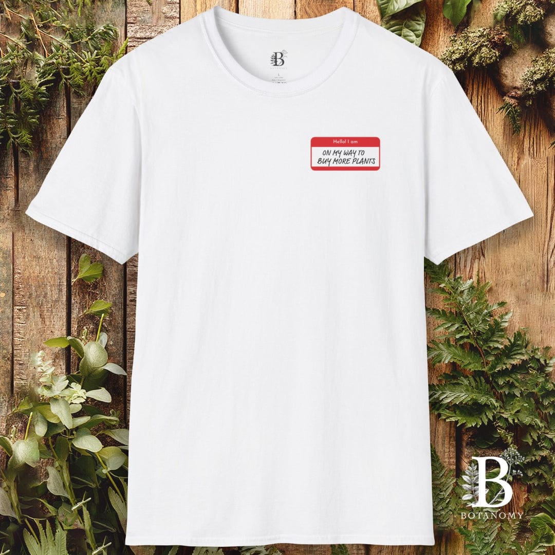 White t-shirt with a name tag graphic on a wooden background with plants
