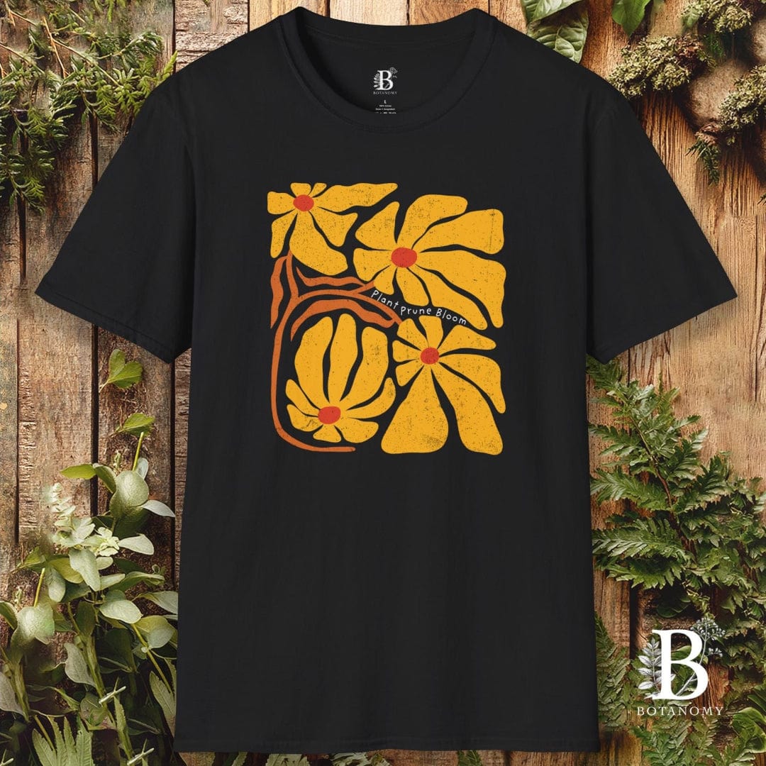 Black t-shirt with yellow floral design on a wooden background