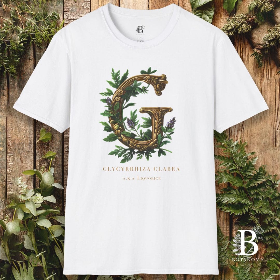 White t-shirt with decorative letter 'G' design on a wooden background