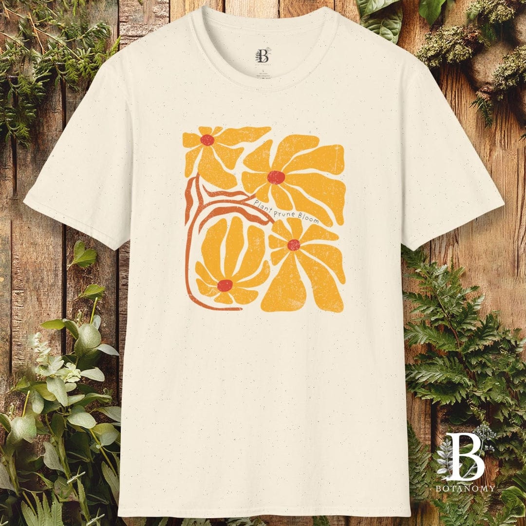 White t-shirt with a yellow floral design on a wooden background