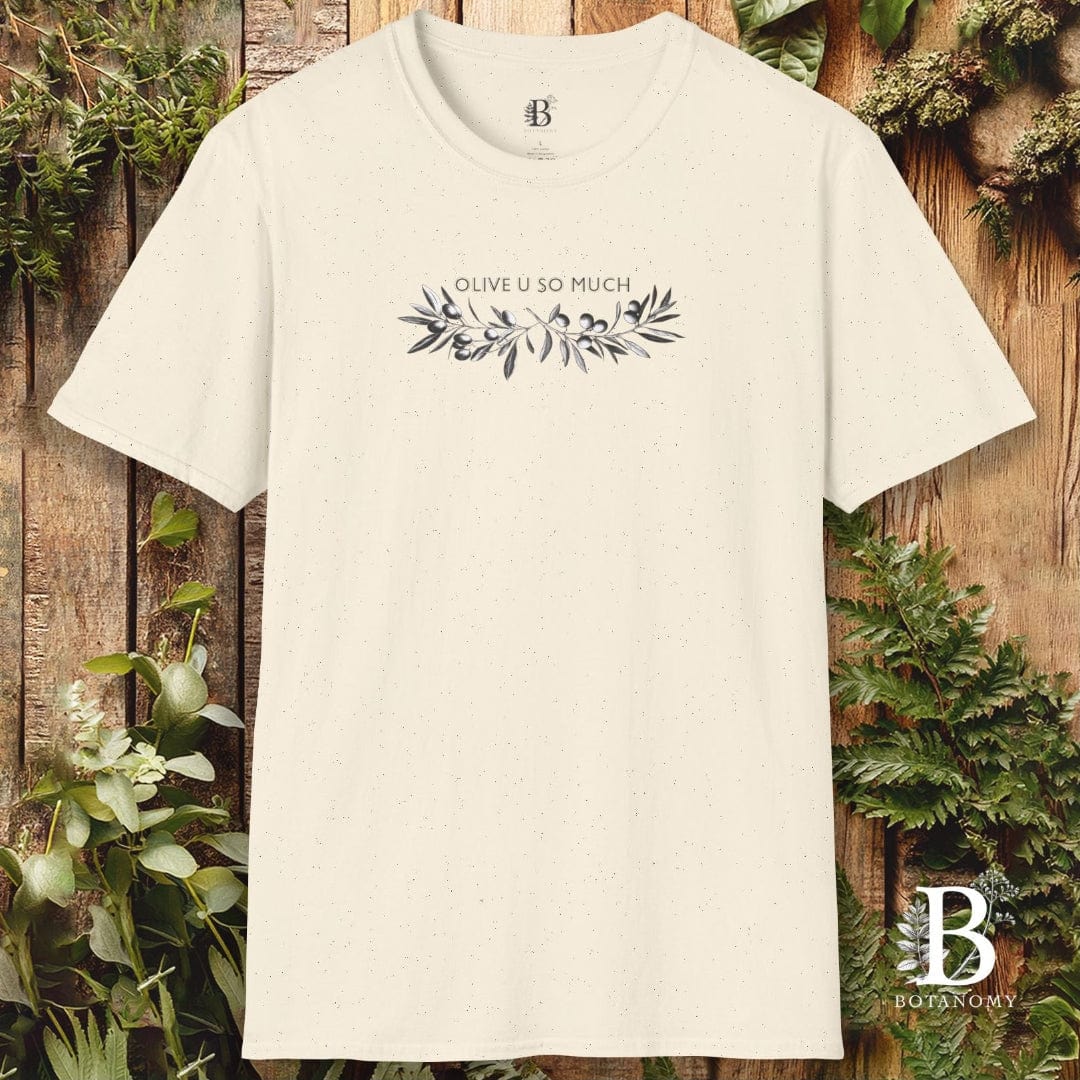 Beige t-shirt with 'Olive U So Much' design on a wooden background with greenery