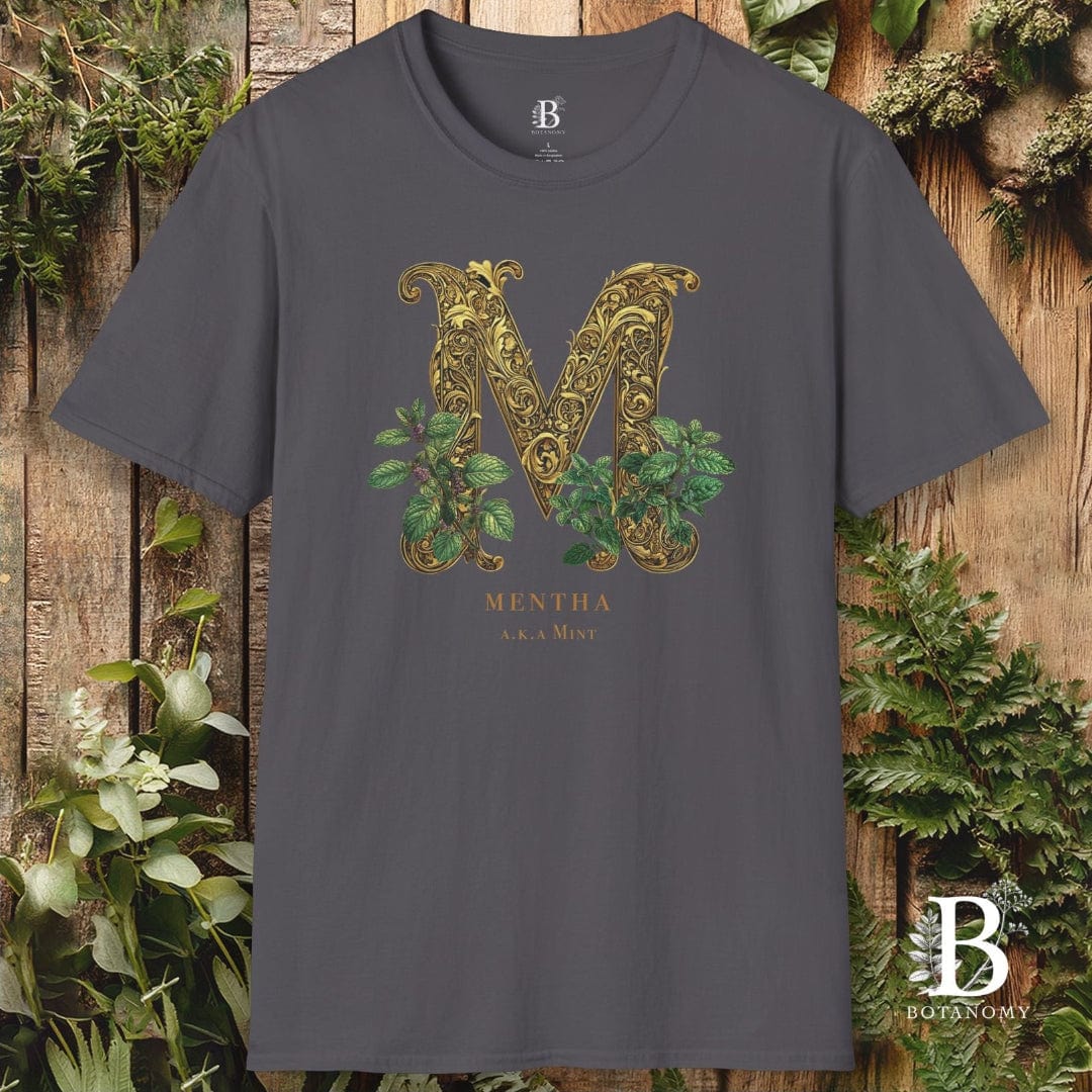 Gray t-shirt with decorative 'M' design and brand logo on a wooden background