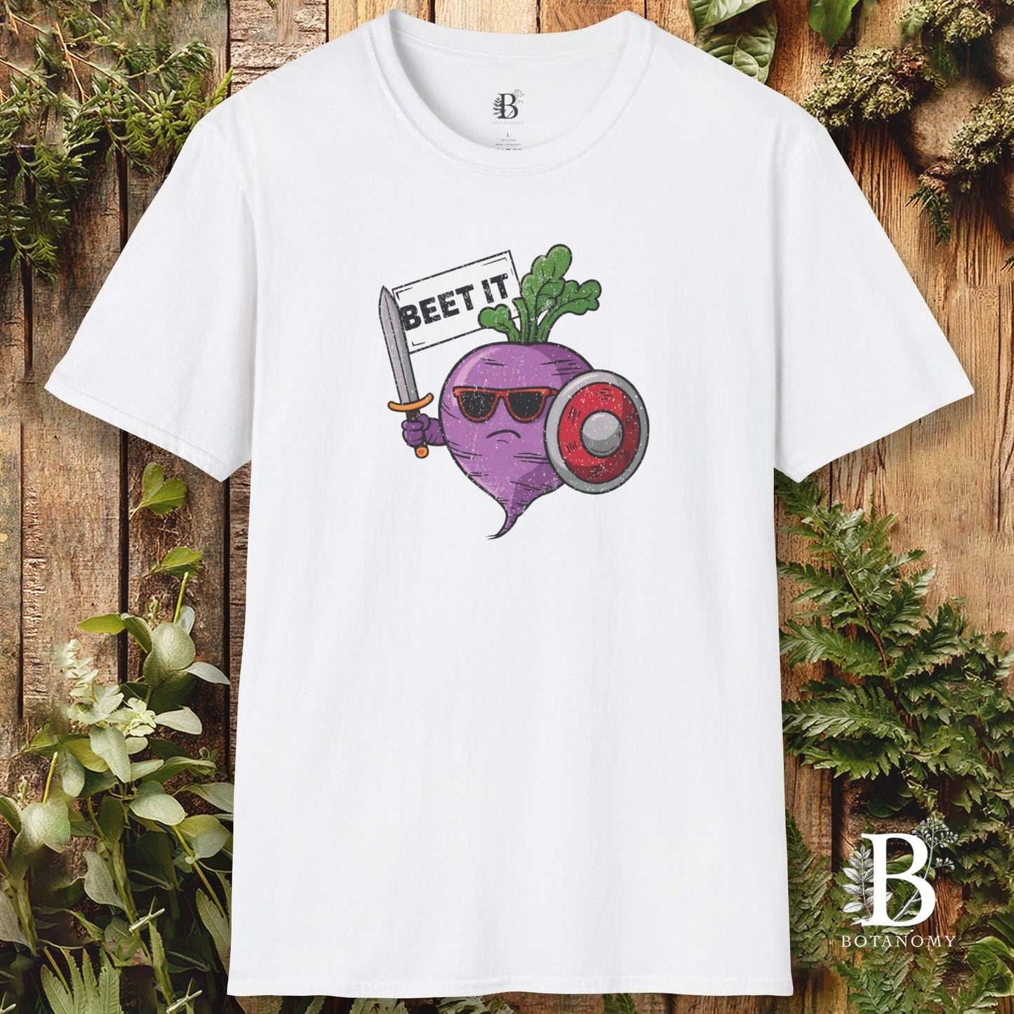 White t-shirt with a graphic design of a beet wearing sunglasses and holding a banner on a wooden background.