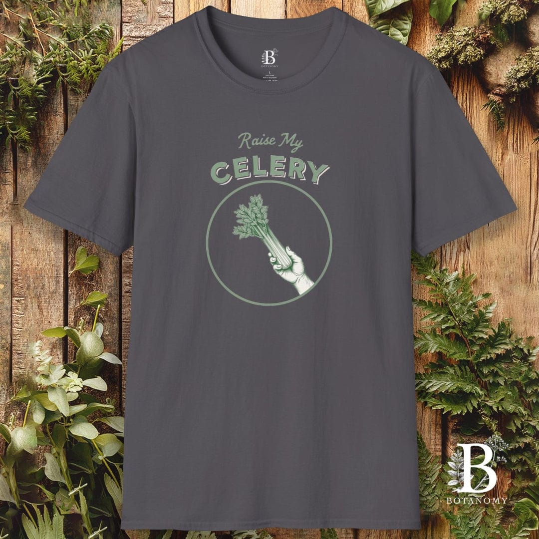 Gray t-shirt with 'Raise My Celery' graphic design on a wooden background with plants.