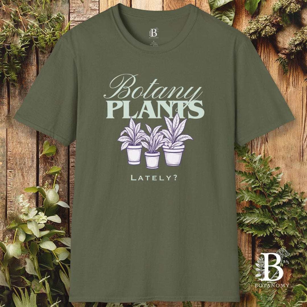 Green t-shirt with 'Botany Plants Lately?' design on a wooden background with plants.