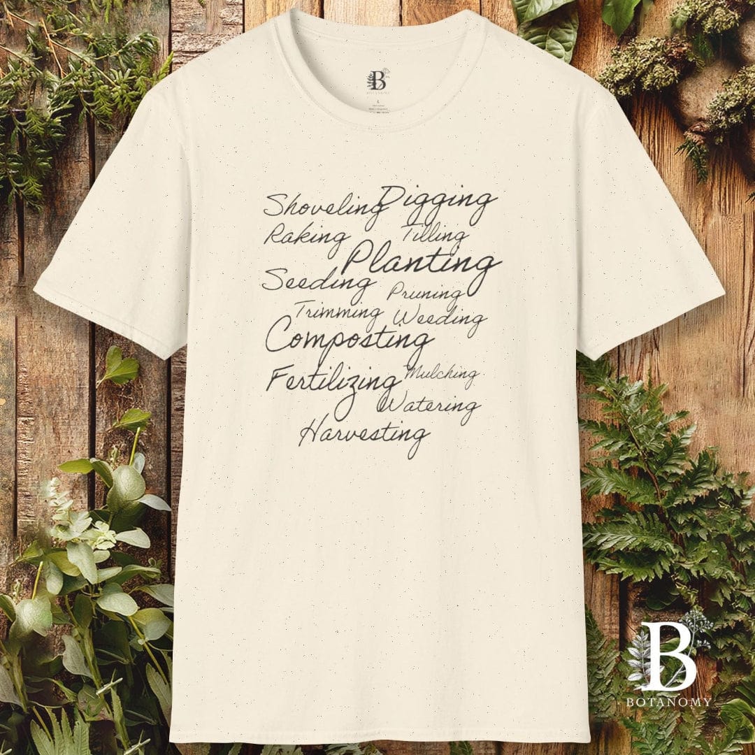 White t-shirt with gardening terms printed on it against a wooden background with plants.