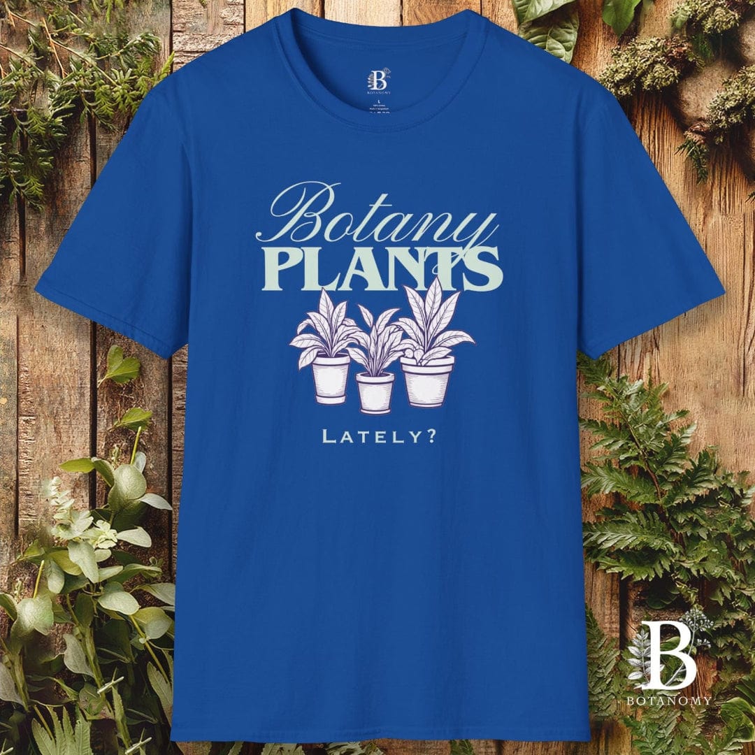 Blue t-shirt with 'Botany Plants Lately?' design on a wooden background with plants.