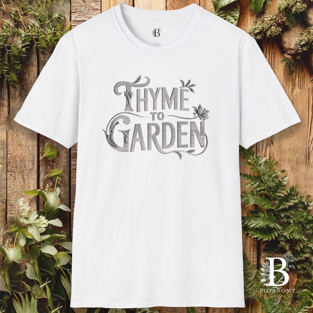 White t-shirt with 'Thyme to Garden' text on a wooden background with plants
