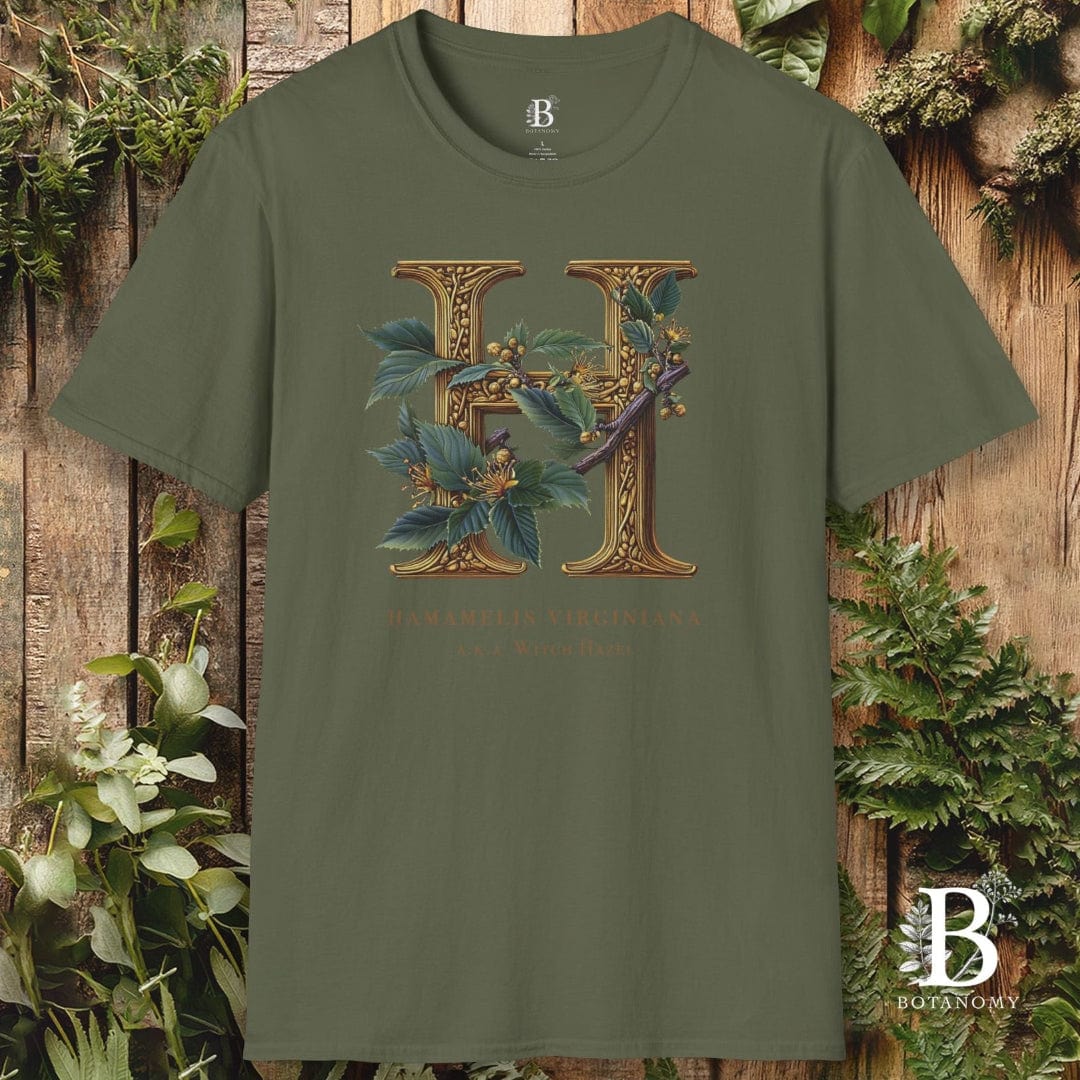 Green t-shirt with floral letter 'H' design on a wooden background