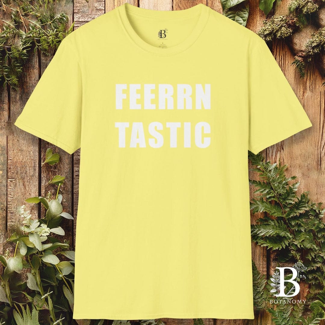 Yellow t-shirt with 'FEERRN TASTIC' text on a wooden background with plants