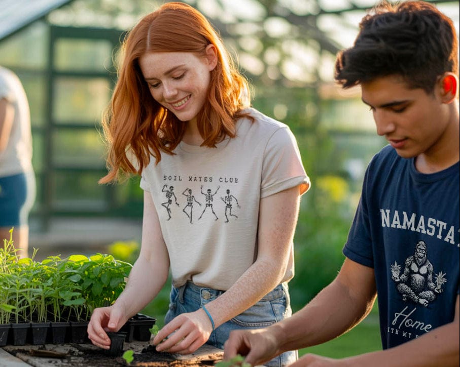 Two people tending to seedlings in a greenhouse setting