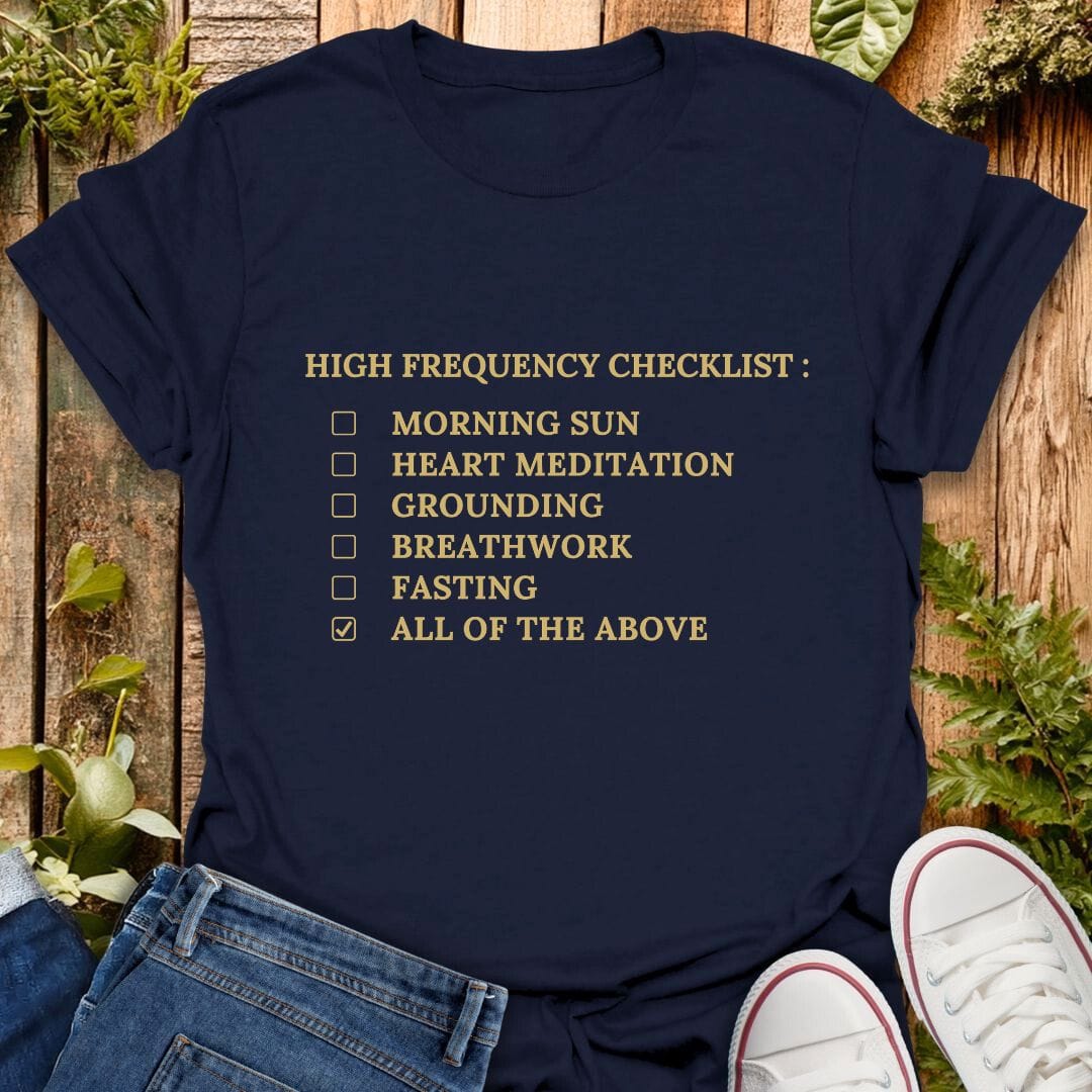 Navy blue t-shirt with 'High Frequency Checklist' text on a wooden surface with plants, jeans and sneakers.