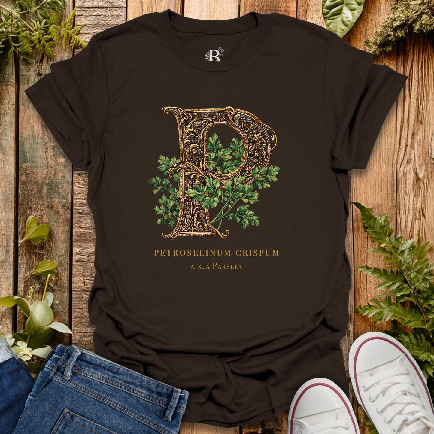 Black t-shirt with decorative letter 'P' design on a wooden surface with plants.
