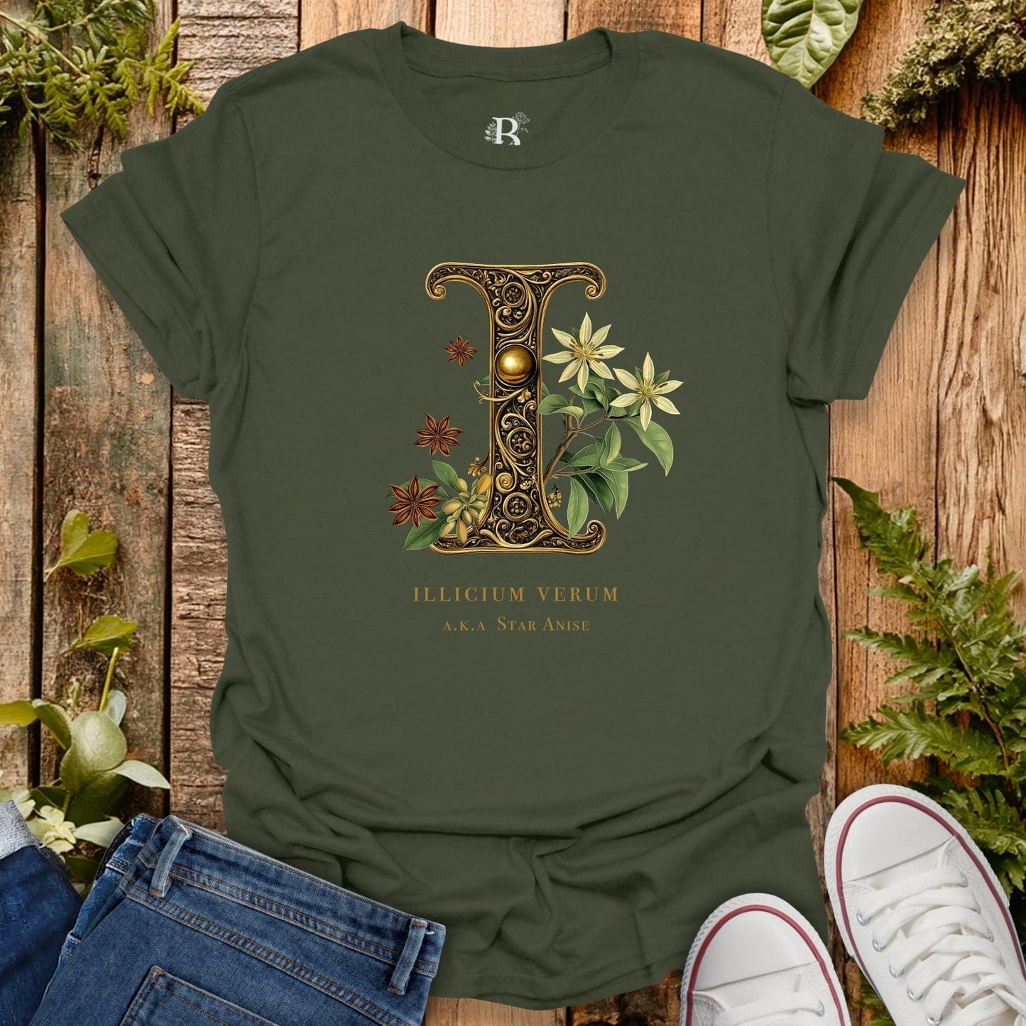 Green t-shirt with decorative letter 'L' design on a wooden surface with plants.