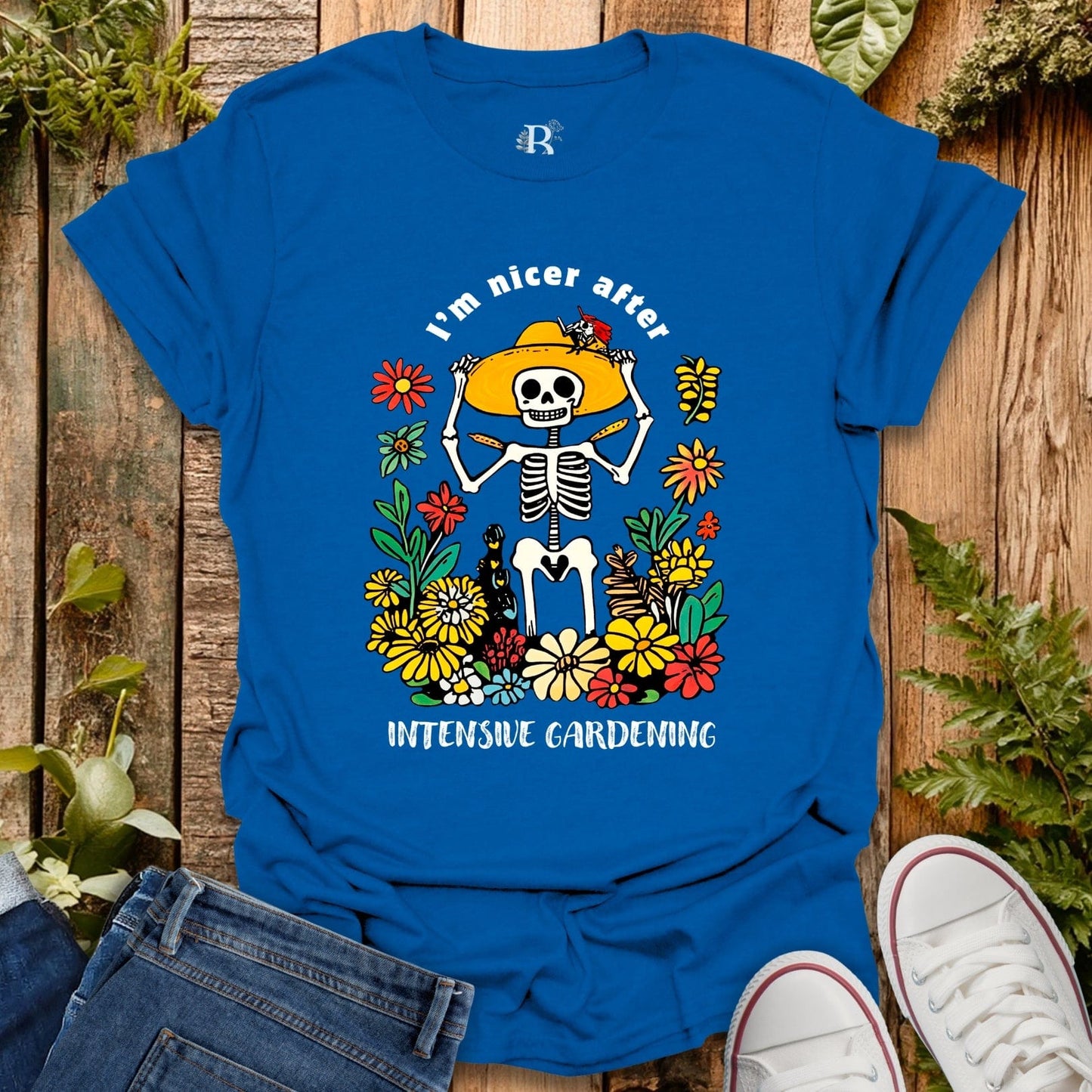 Blue t-shirt with skeleton and flowers design on a wooden background