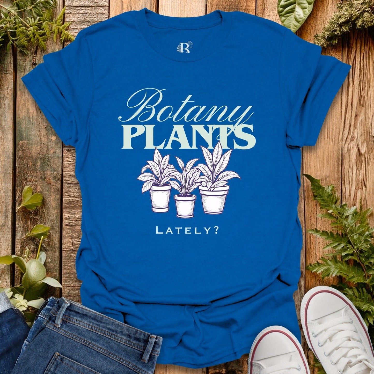 Blue t-shirt with 'Botany PLANTS Lately?' design on a wooden background