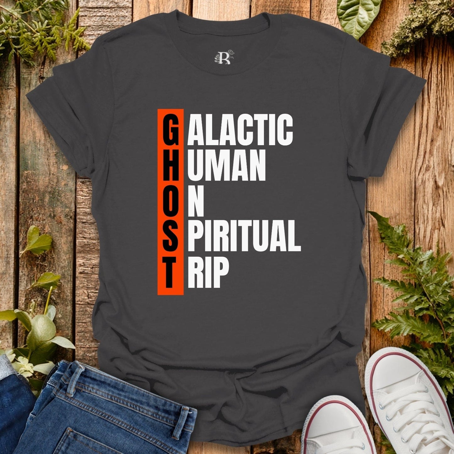 Black t-shirt with text design on a wooden surface with jeans and sneakers.