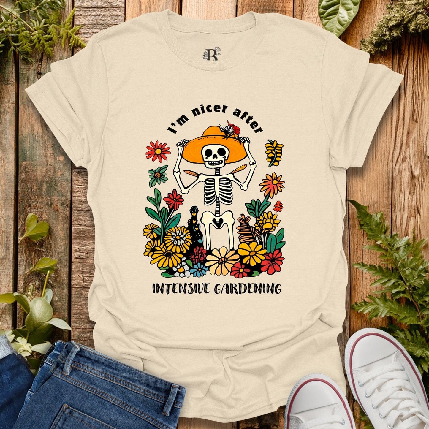 Beige t-shirt with skeleton and flowers design on a wooden background